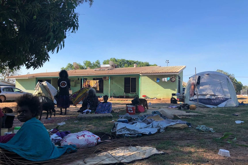 Four residents, a dog, two tents and a green house are pictured