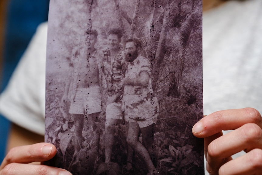 Hands holding an old photo.