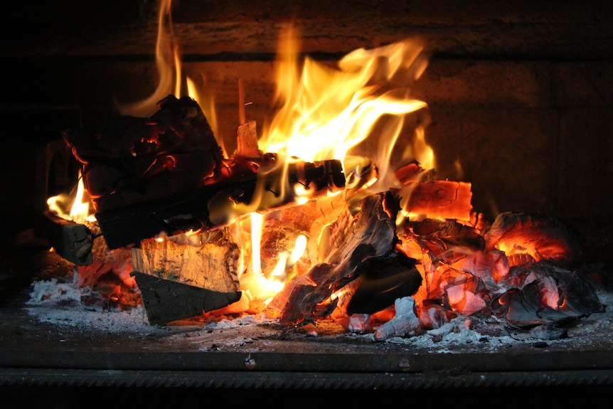 A close up of wood burning in a fireplace.