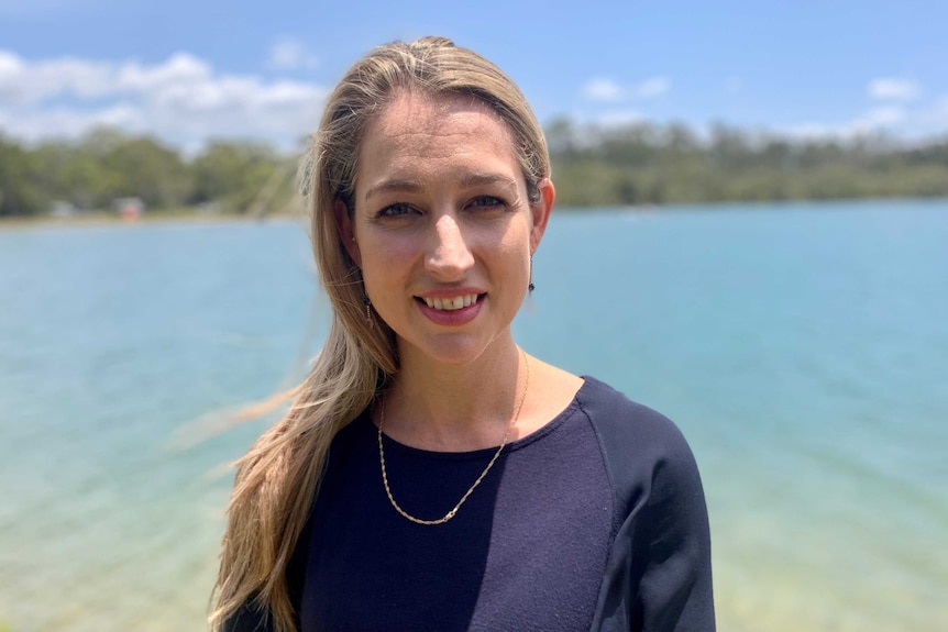 Laura Gerber outside standing beside a river.