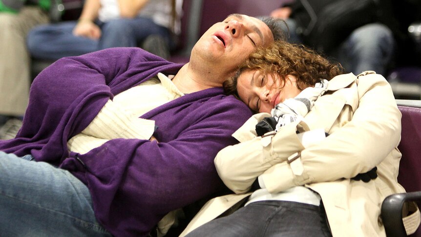 Airline passengers sleep as they wait for flights at Edinburgh airport