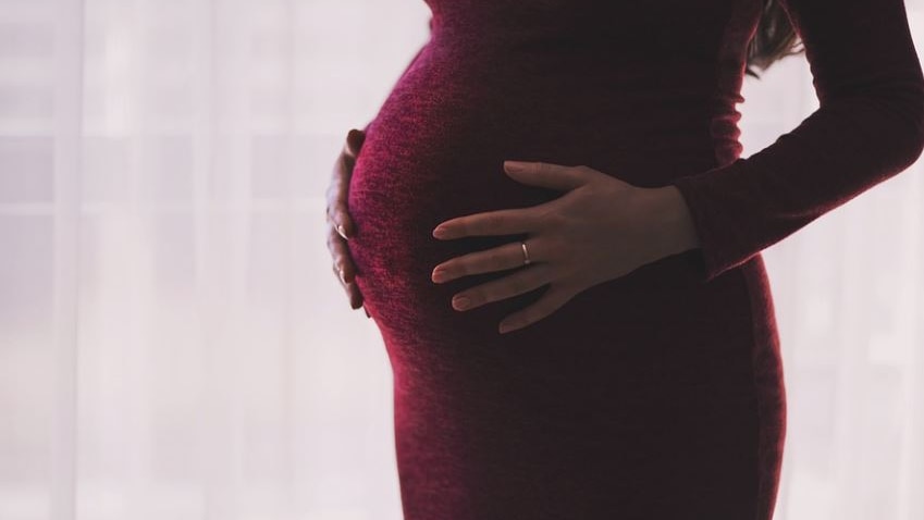 Picture of pregnant woman wearing a red dress 
