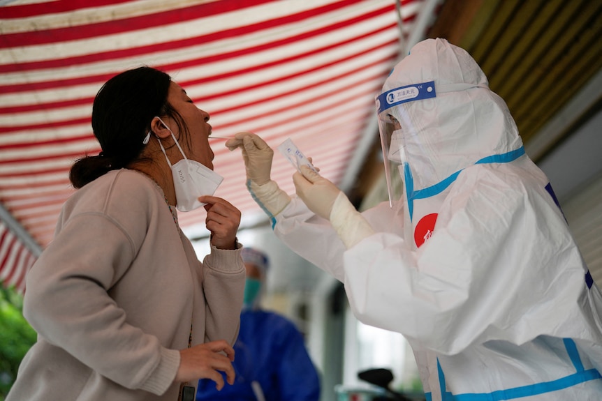 Woman gets swabbed by medical worker.