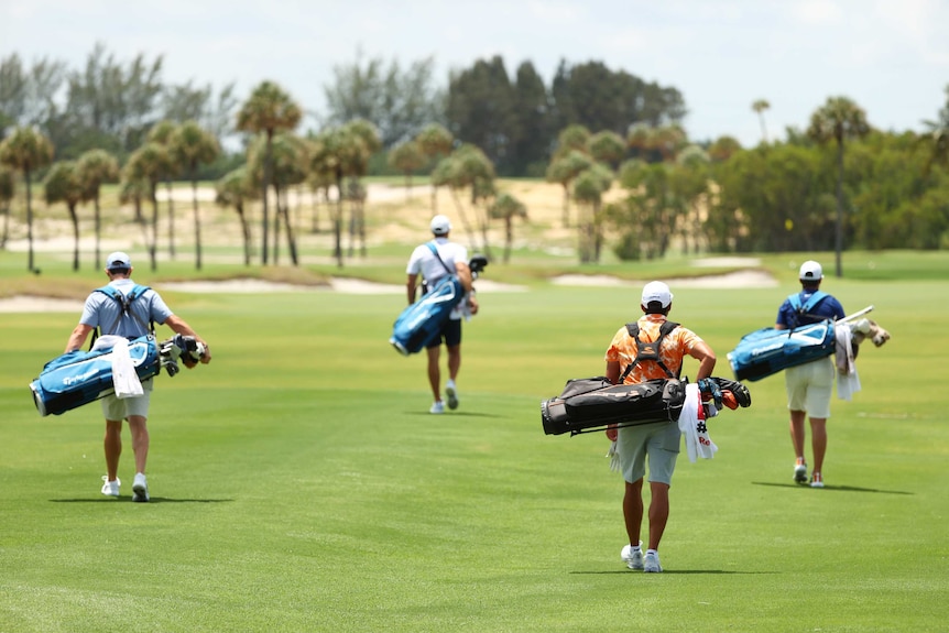 Rory McIlroy, Dustin Johnson, Rickie Fowler and Matthew Wolff carry their clubs