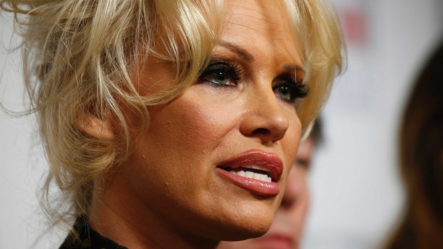 Headshot of Pamela Anderson, looking to the right of the image, mid-speech.