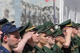 Russian conscripts standing in a line saluting. 