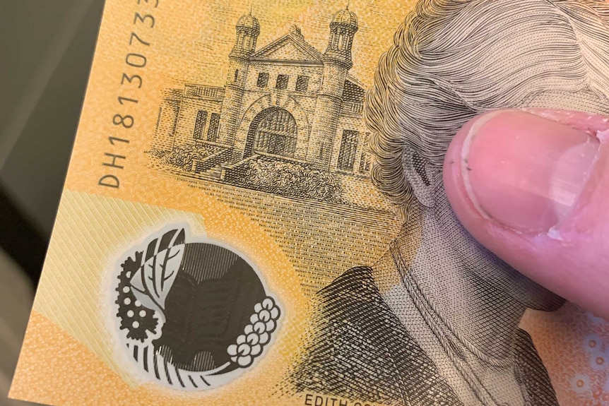 A shot of the $50 Australian note with a thumb holding it.