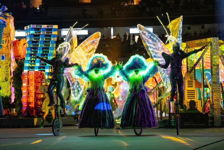 Performers on unicycles representing butterflies are lit up in neon lights during the Paralympics closing ceremony.