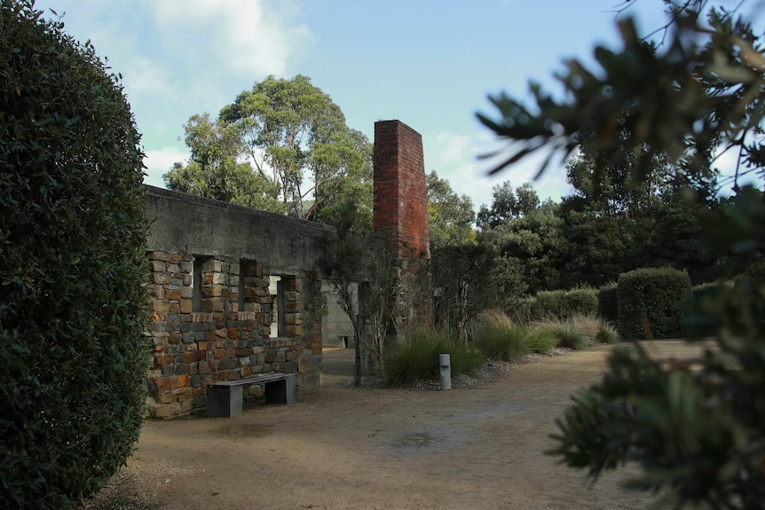 A brick fire place stands in ruins of a building 