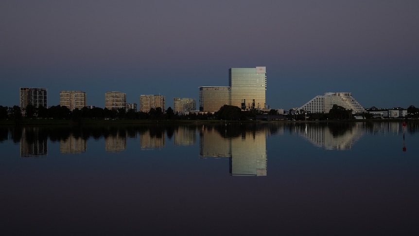 Tall buildings on the banks of a river in the dusk light.