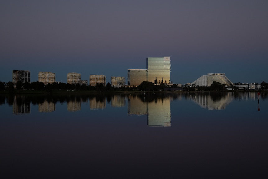 Tall buildings on the banks of a river in the dusk light.