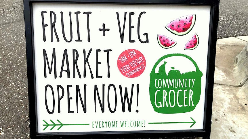 Sandwich board sitting on the ground pointing to the Community Grocer at Pakenham.