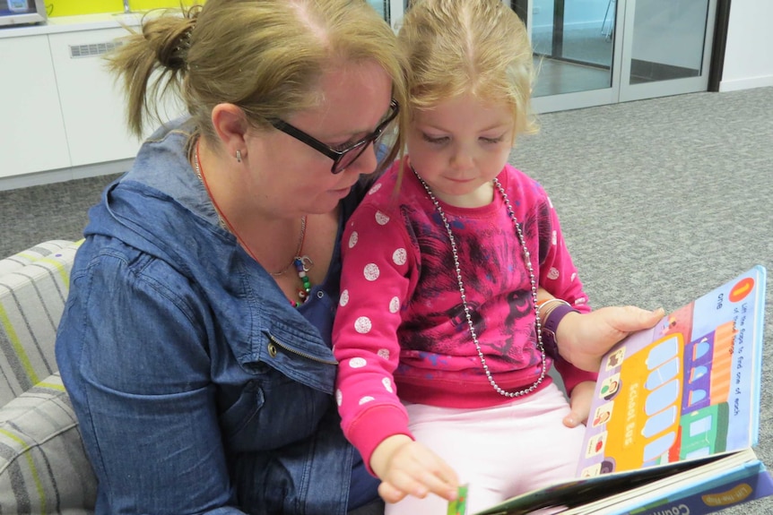 Emma Grimwood and her daughter Stephanie reading a book.