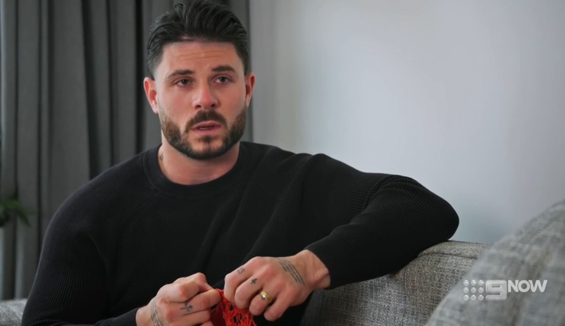 A man looking upset sitting on a couch. 