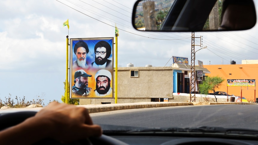 Image of four men on a roadside billboard.