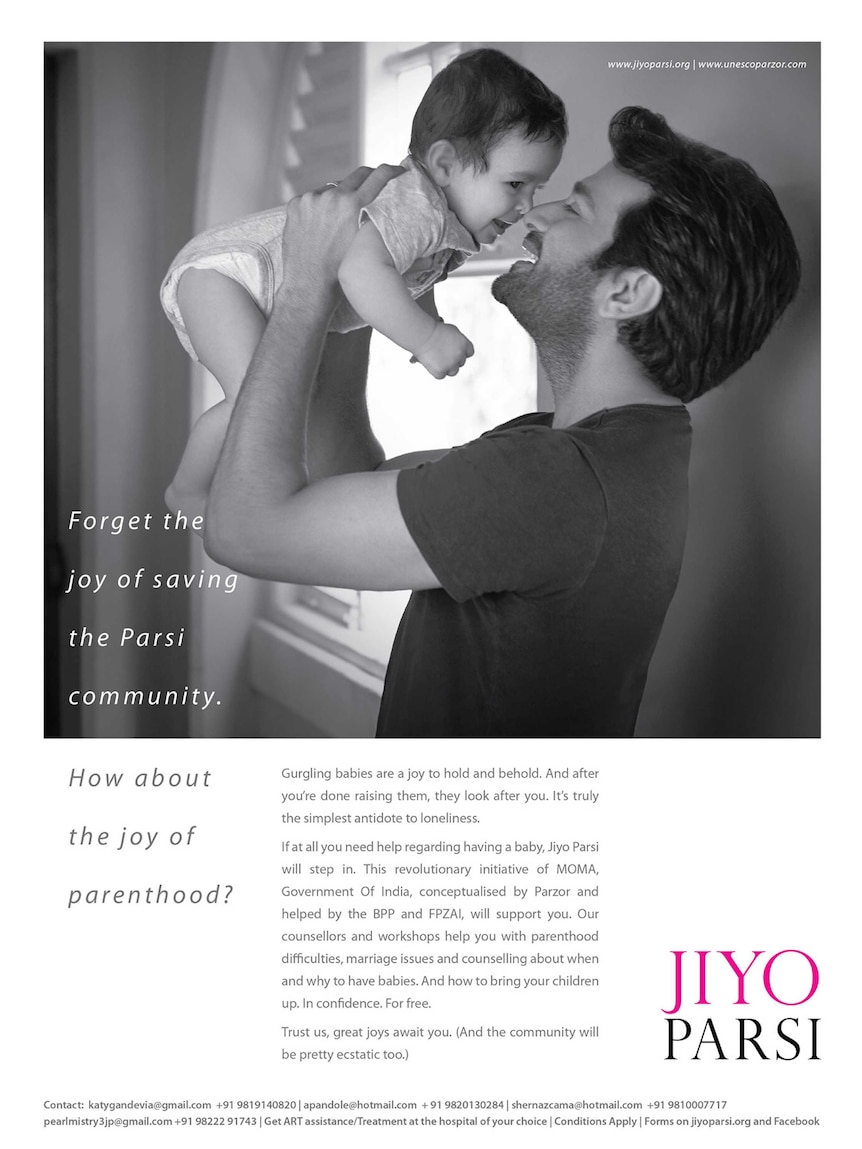 A man holds a baby in a print advertisement.