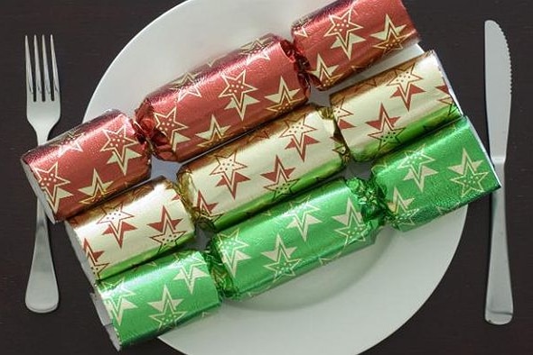 Three Christmas crackers on a plate