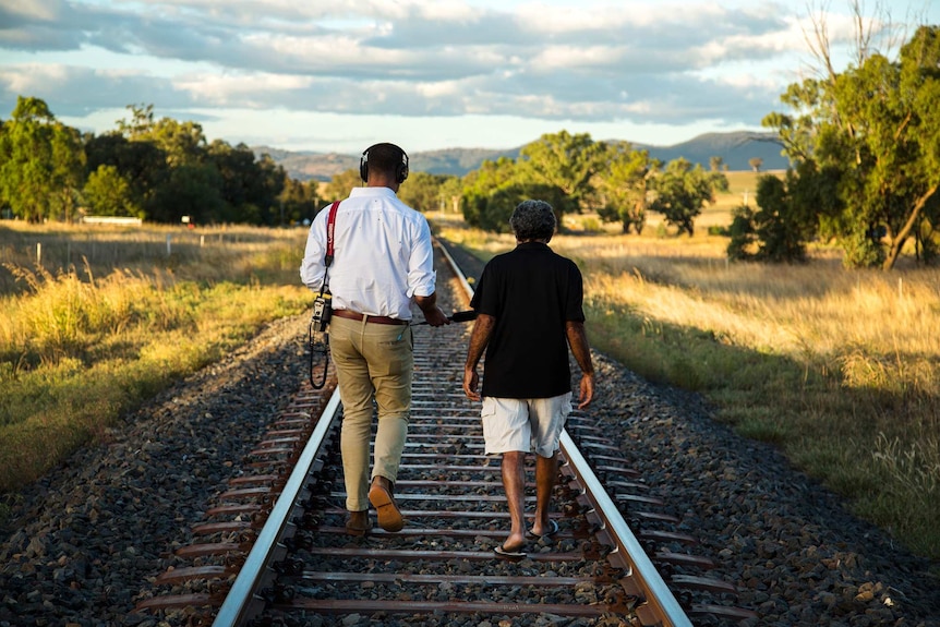 Clarke and Craigie walking along tracks.