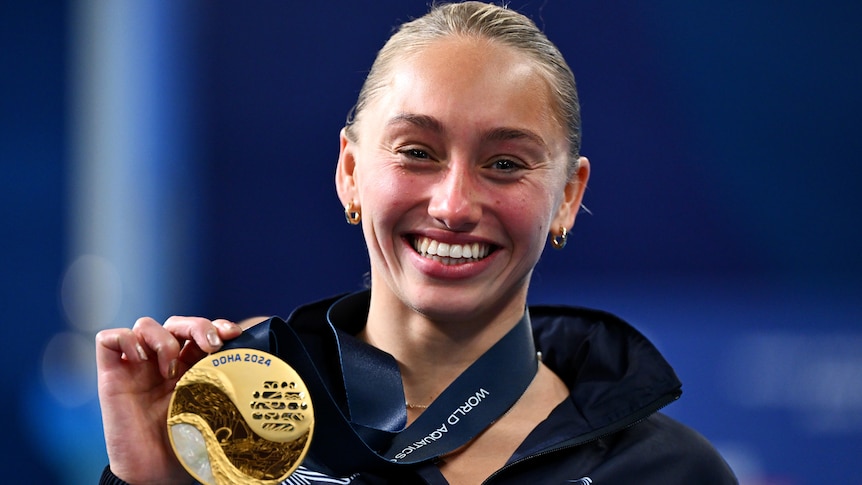 Alysha Koloi shows of her gold medal at the 2024 World Aquatics Championships.