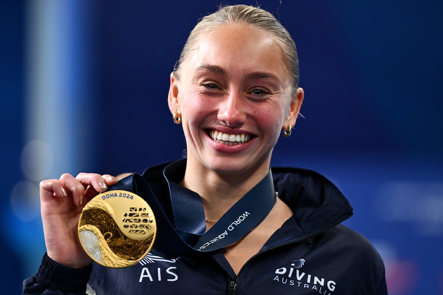 Alysha Koloi shows of her gold medal at the 2024 World Aquatics Championships.