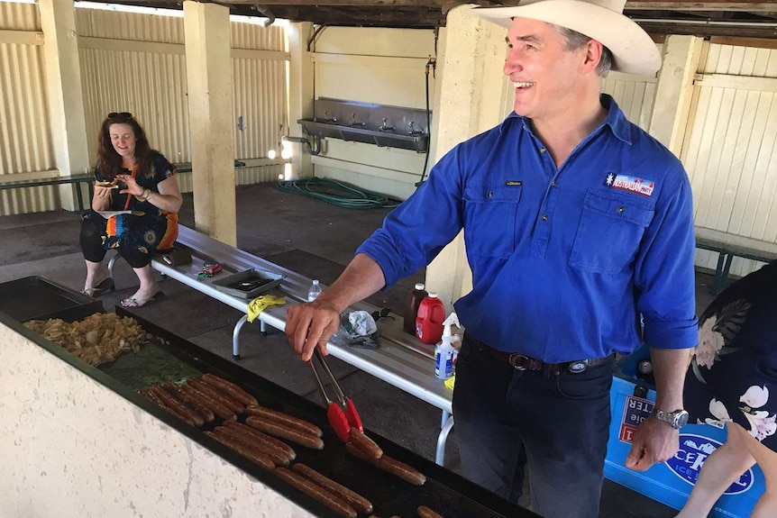 Katter's Australian Party MP Robbie Katter flips a sausage at a voting booth in Mount Isa.