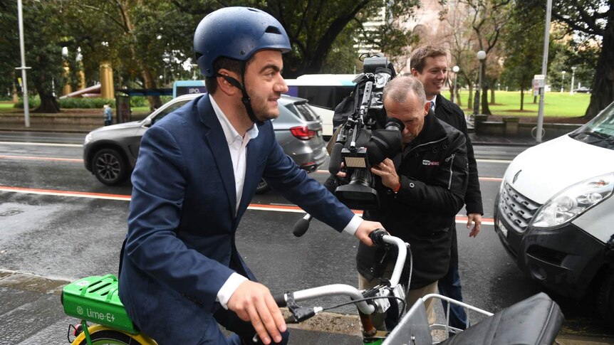 a man on a bike surrounded by cameras