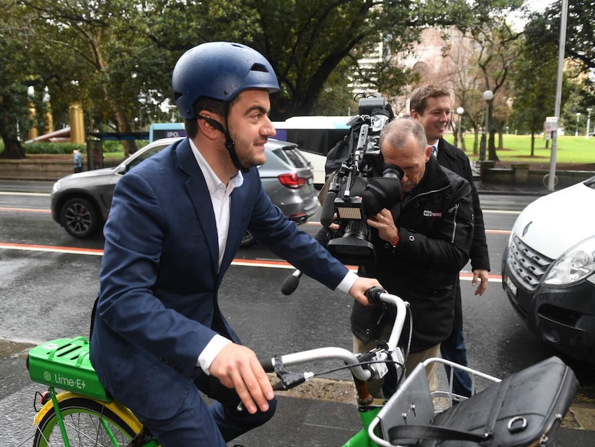 a man on a bike surrounded by cameras