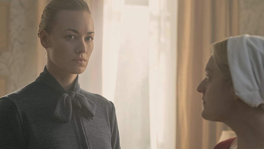 A still image from The Handmaid's Tale shows Yvonne Strahovski's character with a stern expression on her face.