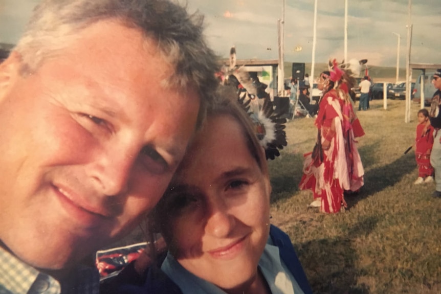 Selfie of Jones and Ferguson with heads together and Indians in traditional dress in the background.