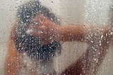 A woman shampoos her hair in a shower