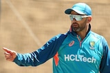 Australia bowler Nathan Lyon points while holding a cricket ball at training.