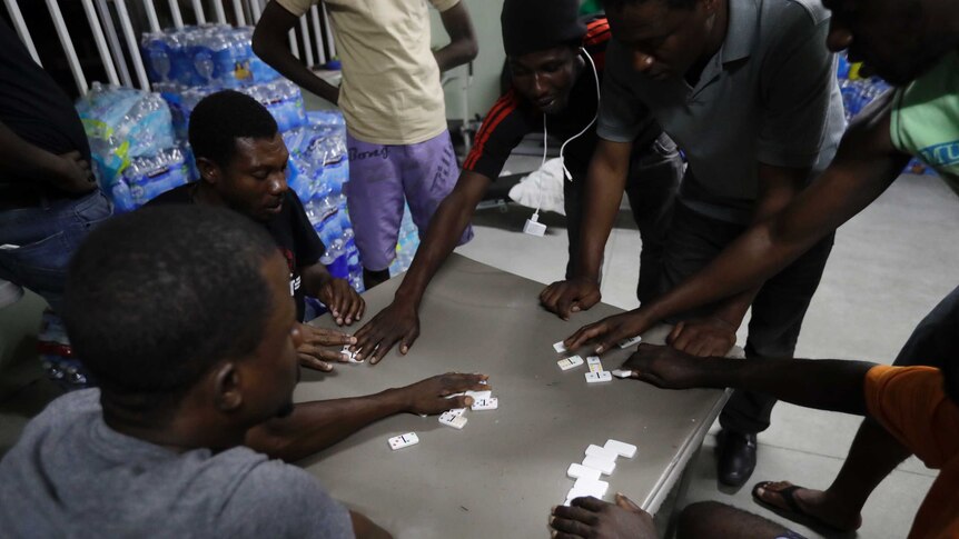 Haitian migrants play dominoes at the Padre Chava migrant shelter, in Tijuana, Mexico.