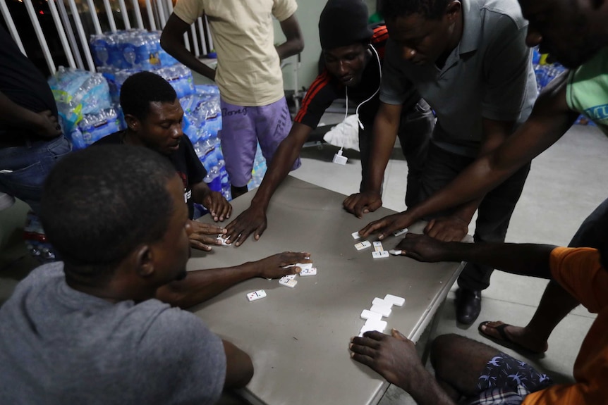 Haitian migrants play dominoes at the Padre Chava migrant shelter, in Tijuana, Mexico.