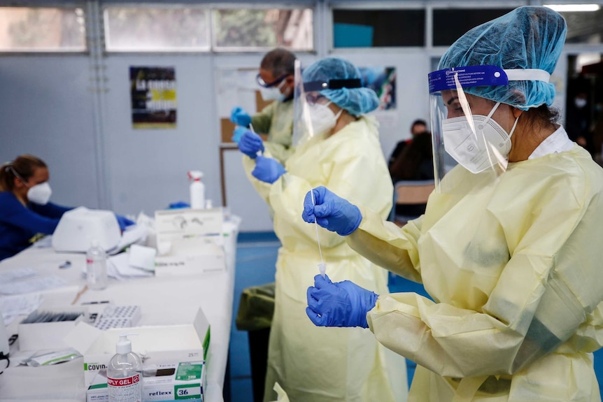 Health workers in full PPE testing COVID swabs