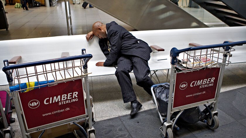 A man sleeps in the departure hall of Copenhagen Airport April 16, 2010.