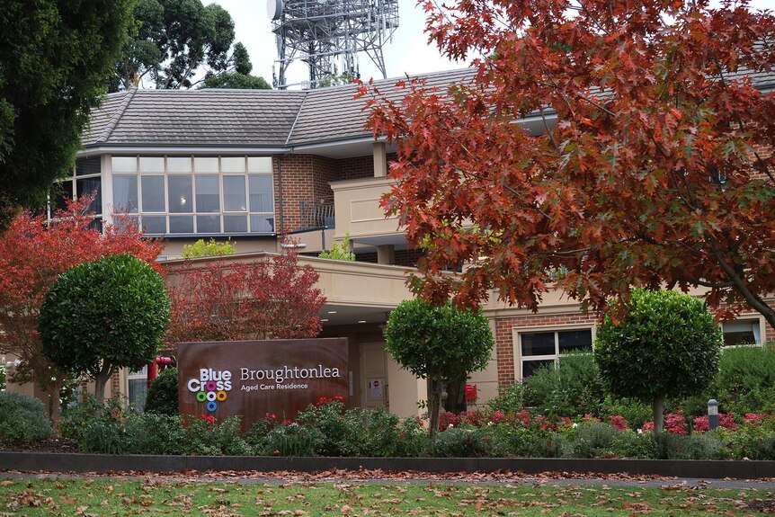 A large aged care facility surrounded by leafy trees