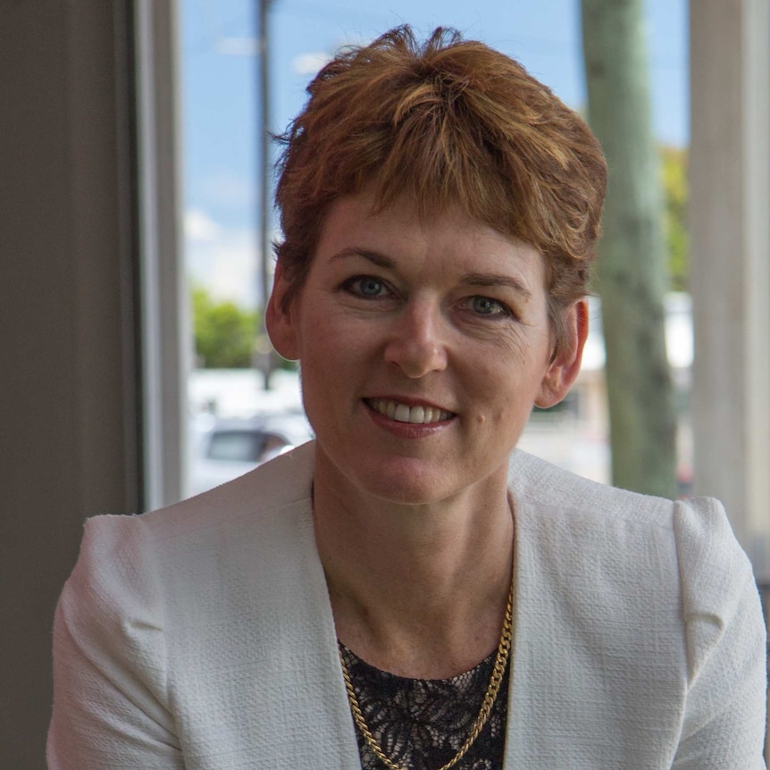 Smiling woman with short hair wearing white jacket