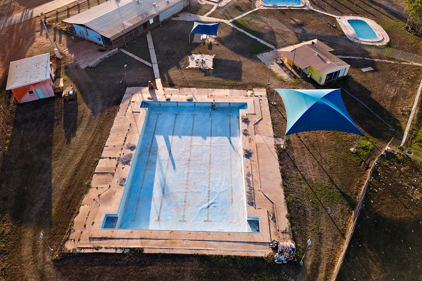 A drone shot of an empty pool in a remote community.