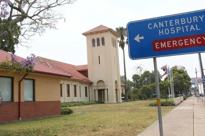 A hospital with tower on a lawn