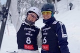 Danielle Scott and Laura Peel smile and stand next to each other in the snow