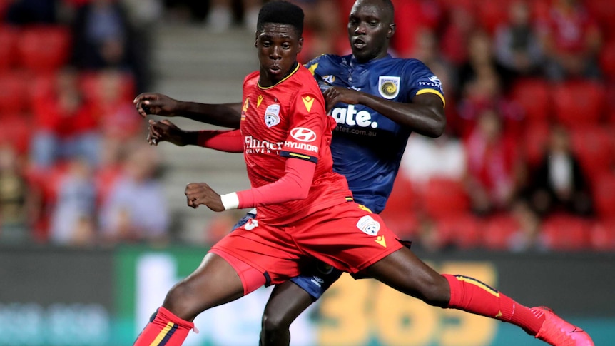 Mohamed Toure is being pressure from behind as he stretches his left lag backwards in preparation to shoot.