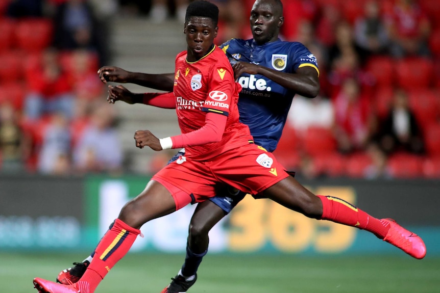 Mohamed Toure is being pressure from behind as he stretches his left lag backwards in preparation to shoot.