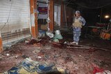 An police officer inspects the site of a bomb attack at a coffee shop in Kirkuk, July 12, 2013