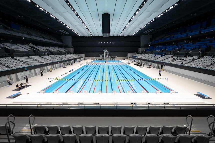 A swimming pool with eight lanes and rows of seats on three sides.