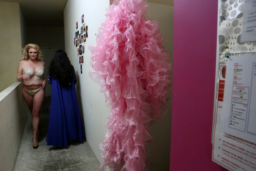 A frilly pink costume hangs backstage before performance time.