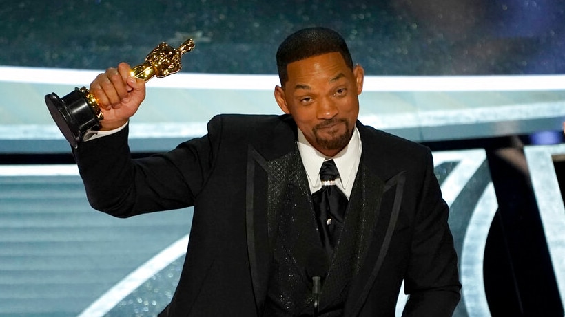 Will Smith with his trophy on stage.
