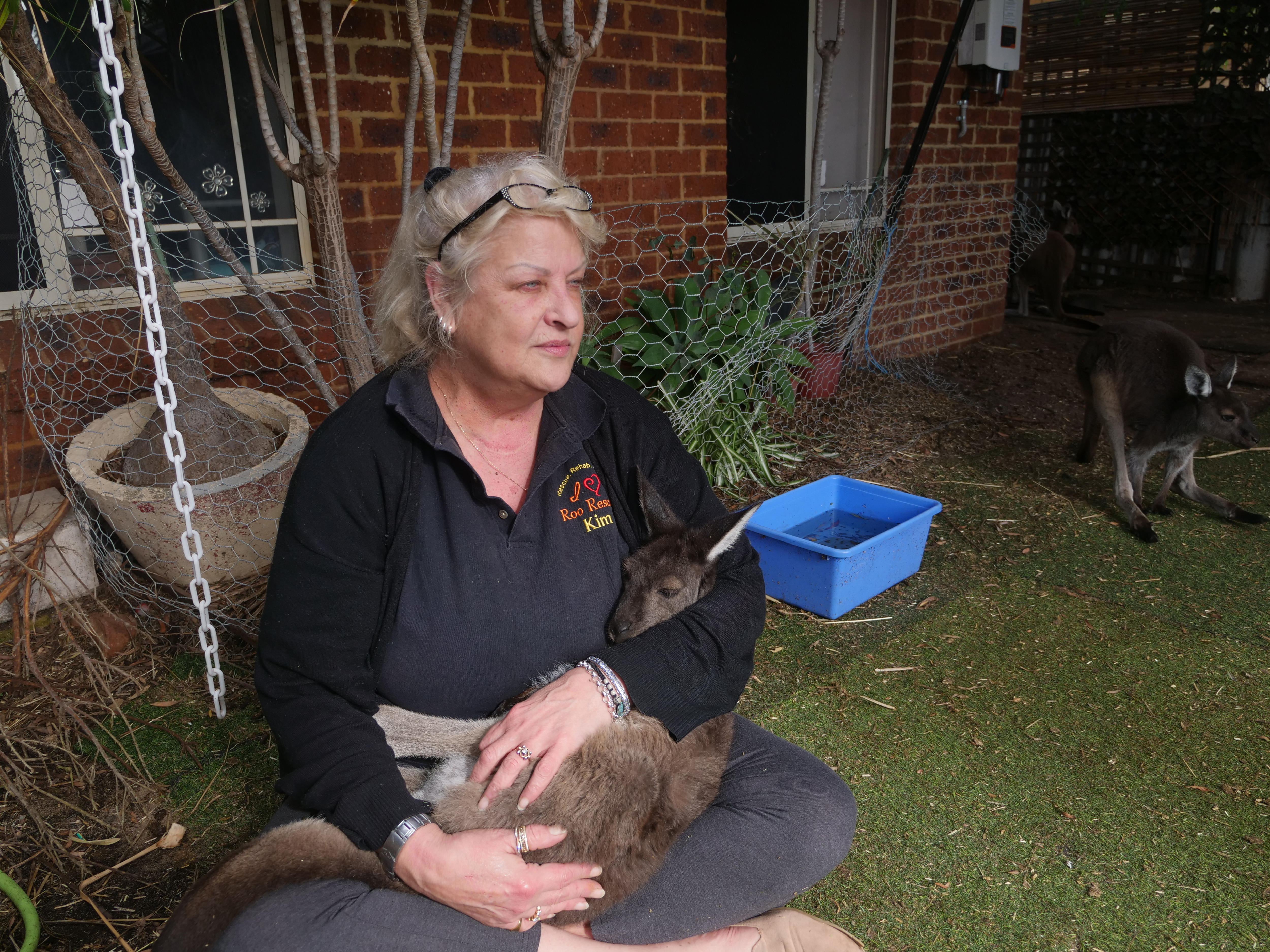 Una mujer sosteniendo un canguro.