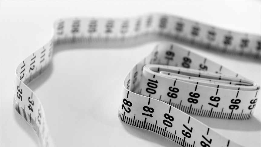 Tape measure coiled on a white table.