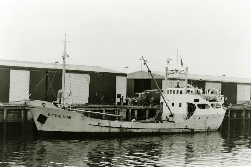 Black and white imaged of a ship berthed at a dock