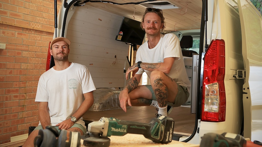 Callum Keyssecker and Chris Holmes sit in a van they are renovating at their workshop in Kiama.